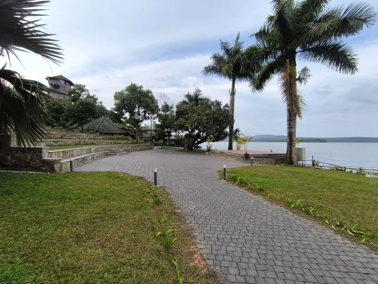 Lakeside grounds with stone terraces at Coorg Jungle Camp Resort