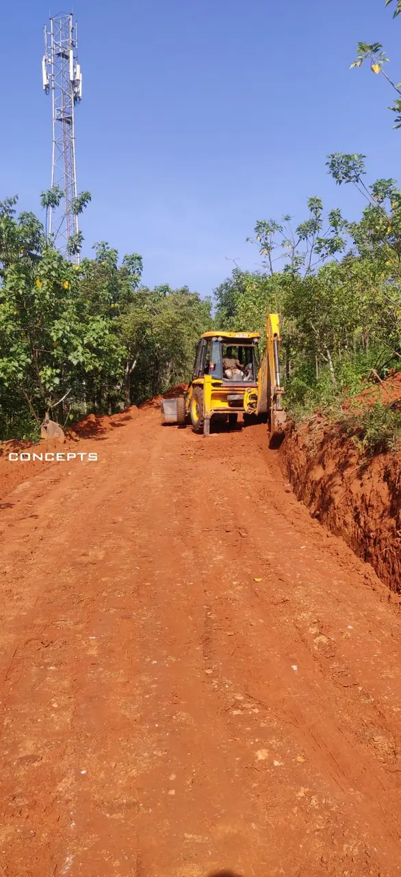 CONCEPTS backhoe cutting a new access road on a hill site in Kodagu