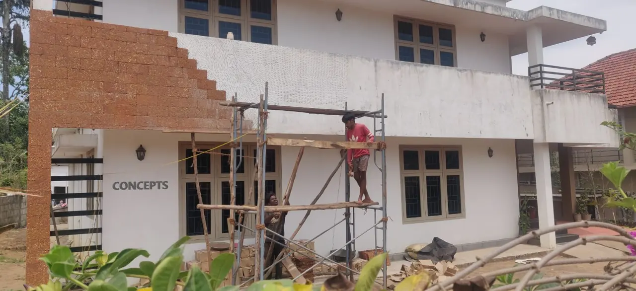 CONCEPTS crew on scaffolding fixing laterite stone cladding, Virajpet